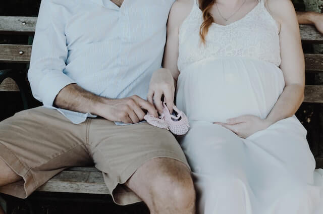 Mature couple with baby shoes in their hands. 