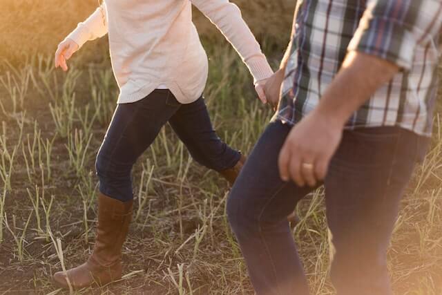 Local couple holding hands in the field. 