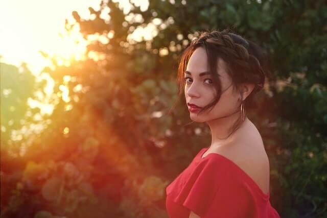 Sensual Latin lady dressed in red, loving the sunset