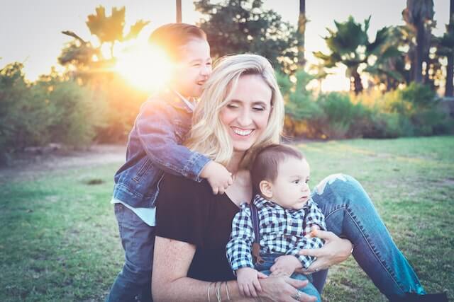 Happy mother playing with her kids in a garden.